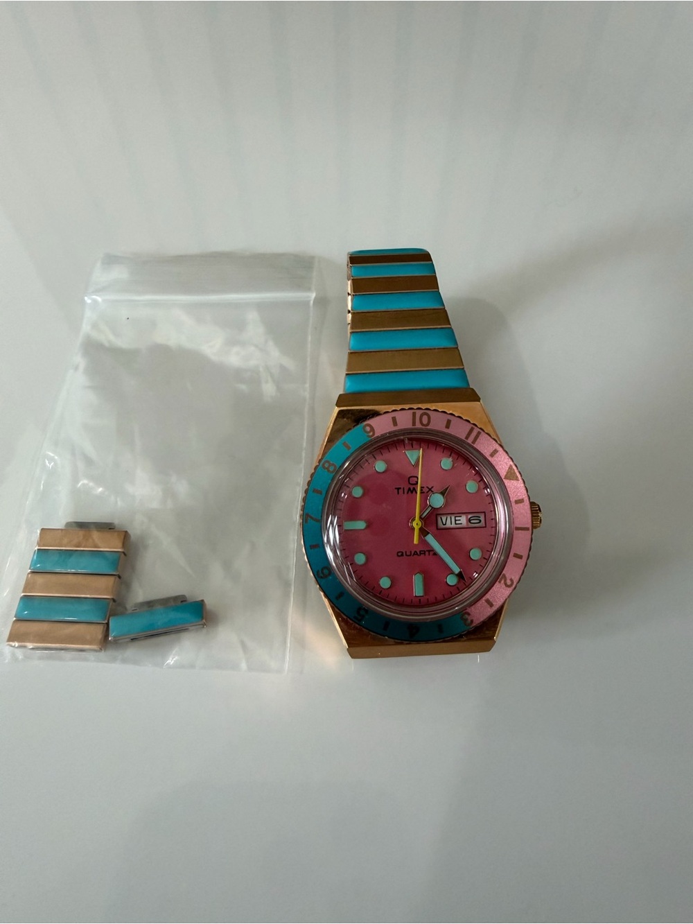 Timex Gold-Tone Watch with Pink Dial and Turquoise Accents
Needs a new battery